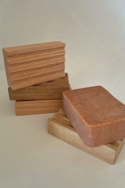 Porte-savon en bois brut "Coeur de Chêne" présenté avec un savon solide à l'argile rouge